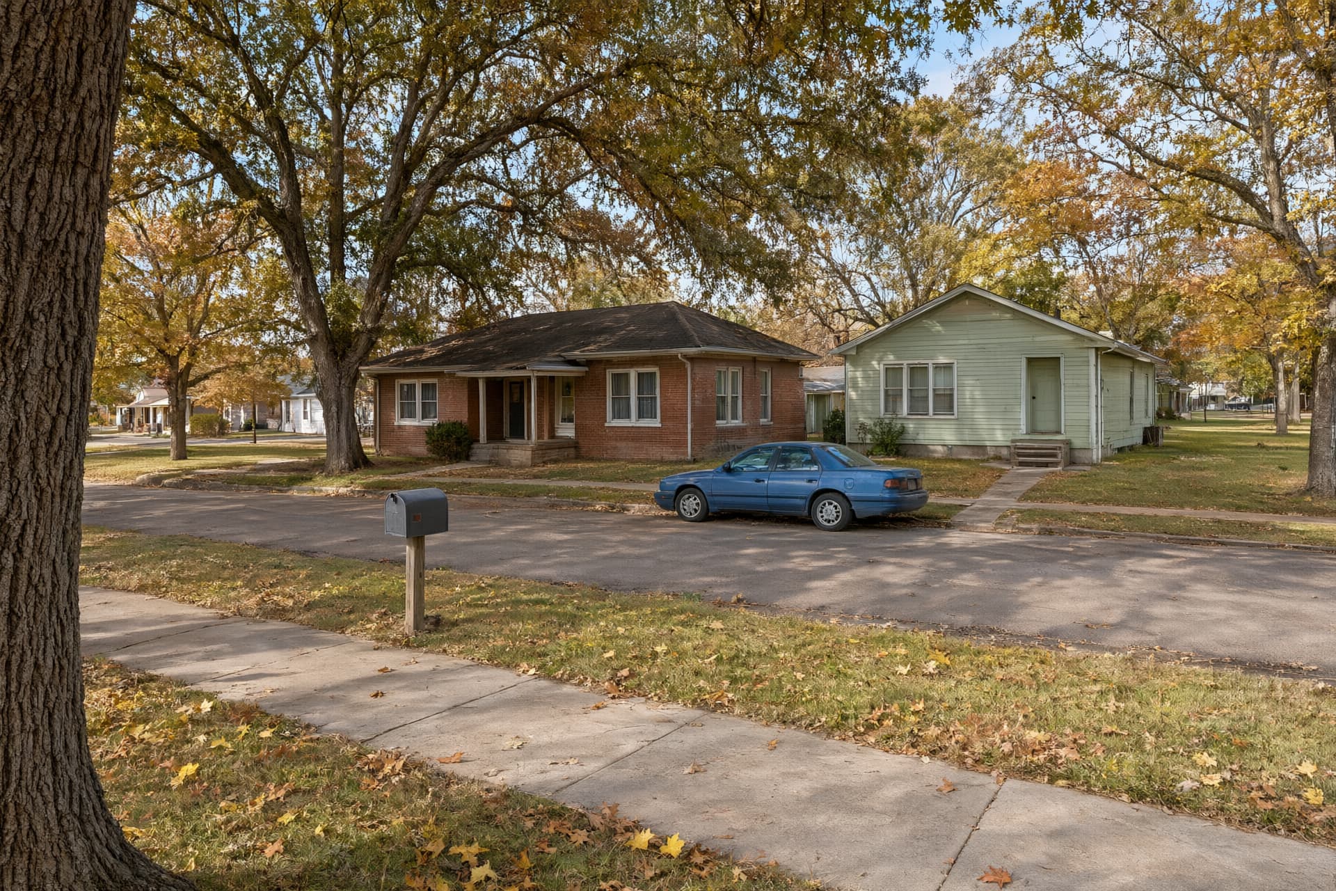 Brick and frame houses under big water oaks on an older street, the kind of block we work on in Paragould, AR